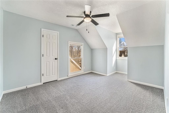 additional living space with carpet flooring, a textured ceiling, a ceiling fan, and baseboards