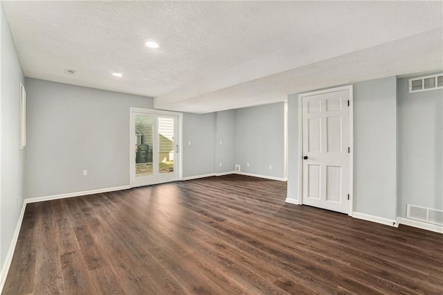 unfurnished room with dark wood finished floors, visible vents, and baseboards