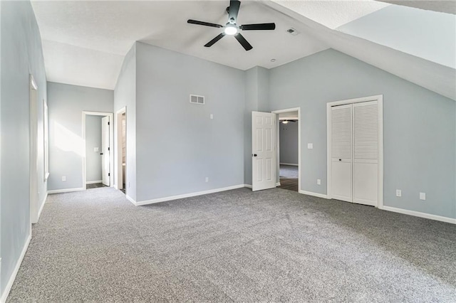 unfurnished bedroom with lofted ceiling, carpet flooring, baseboards, and visible vents