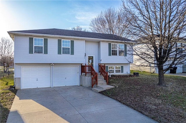 raised ranch with a garage, central air condition unit, and concrete driveway