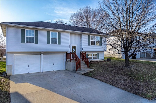 bi-level home featuring concrete driveway and an attached garage