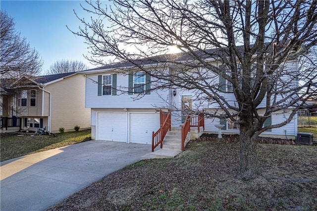 view of front facade with a garage, cooling unit, and concrete driveway