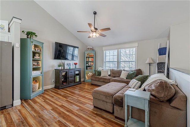 living area with high vaulted ceiling, baseboards, light wood-style floors, and a ceiling fan