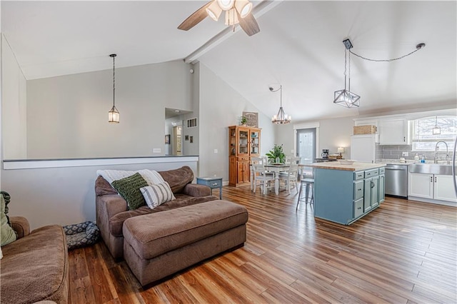 living room featuring wood finished floors, beamed ceiling, ceiling fan with notable chandelier, and high vaulted ceiling