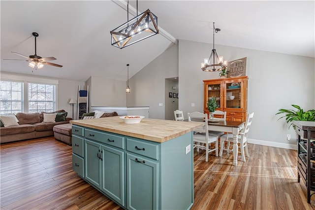 kitchen with ceiling fan with notable chandelier, wooden counters, wood finished floors, and green cabinetry