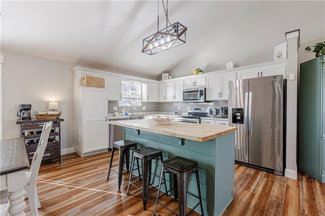 kitchen featuring white cabinets, appliances with stainless steel finishes, and wood counters