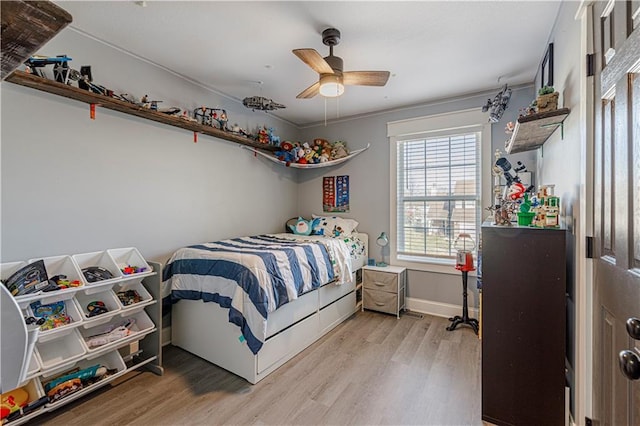 bedroom with baseboards, light wood-type flooring, and ceiling fan