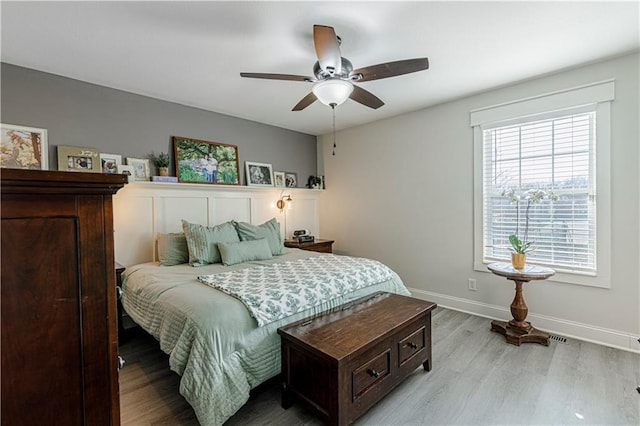 bedroom with light wood-style flooring, baseboards, and ceiling fan