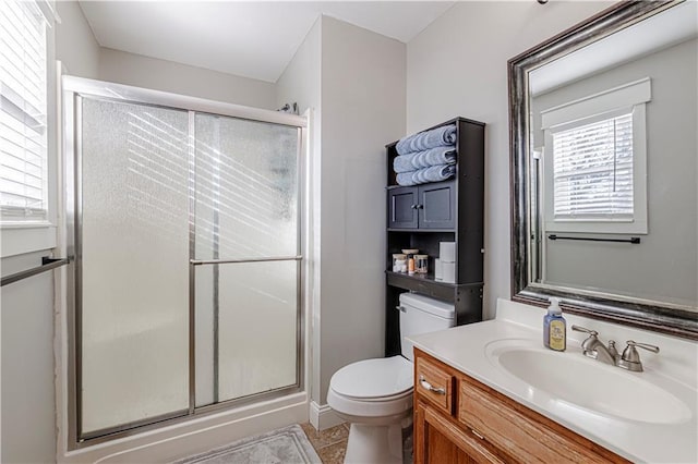 full bath featuring vanity, a shower stall, toilet, and tile patterned floors