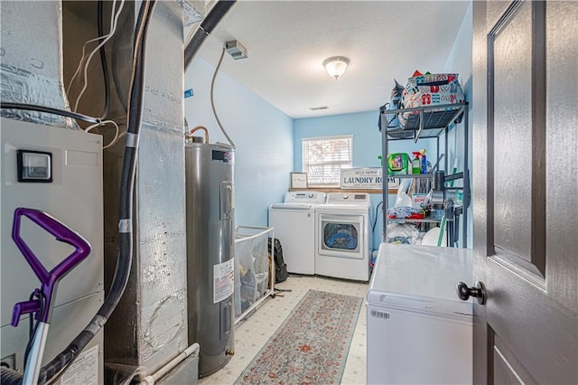 laundry room featuring a textured ceiling, laundry area, water heater, and washing machine and clothes dryer