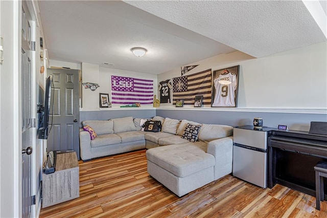 living room with a textured ceiling and wood finished floors