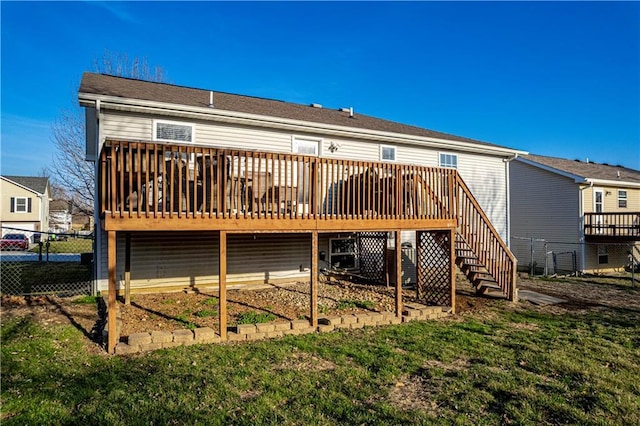 back of property featuring stairway, a lawn, a wooden deck, and fence