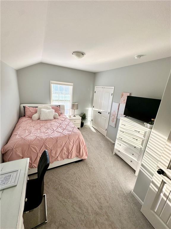 carpeted bedroom featuring vaulted ceiling