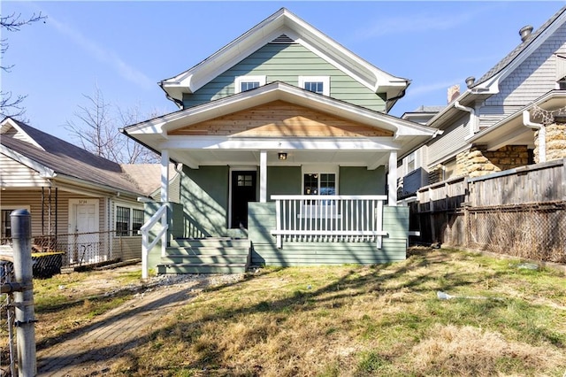 view of front facade featuring fence and covered porch