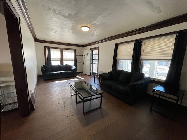 living area featuring hardwood / wood-style floors, baseboards, a textured ceiling, and ornamental molding