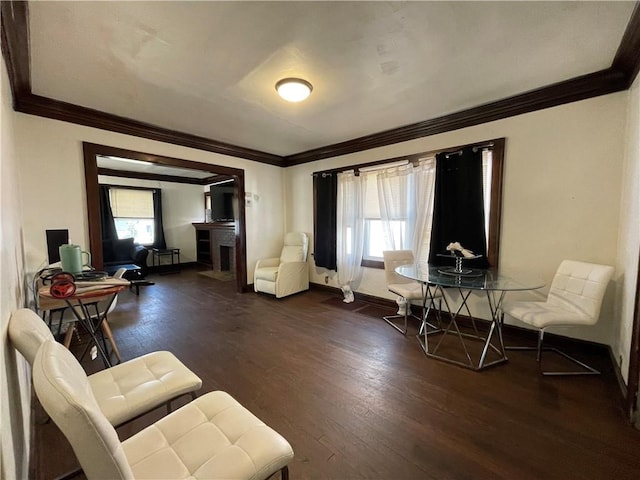 living area featuring baseboards, a healthy amount of sunlight, dark wood-style flooring, and crown molding