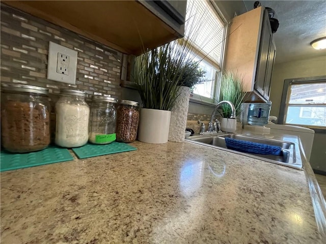 interior space featuring a wealth of natural light, light countertops, speckled floor, and a sink