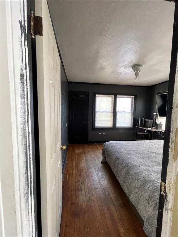 bedroom with dark wood-type flooring and a textured ceiling