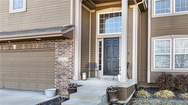 entrance to property with brick siding and a garage