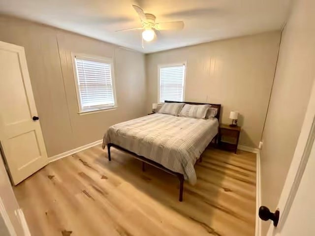 bedroom featuring a ceiling fan, baseboards, and light wood finished floors