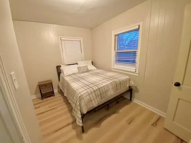 bedroom featuring baseboards and wood finished floors