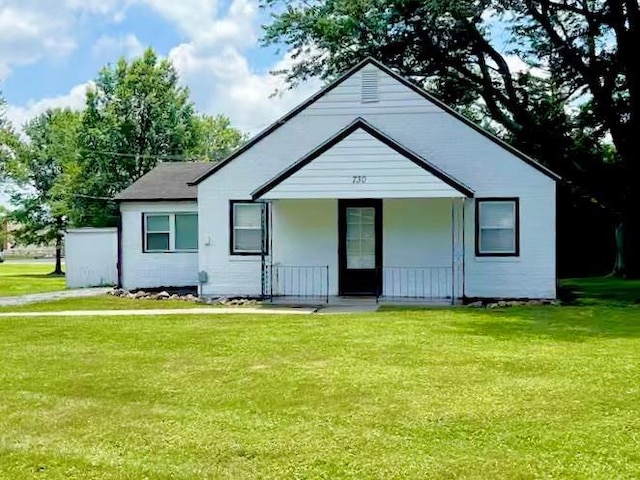 view of front facade with covered porch and a front yard