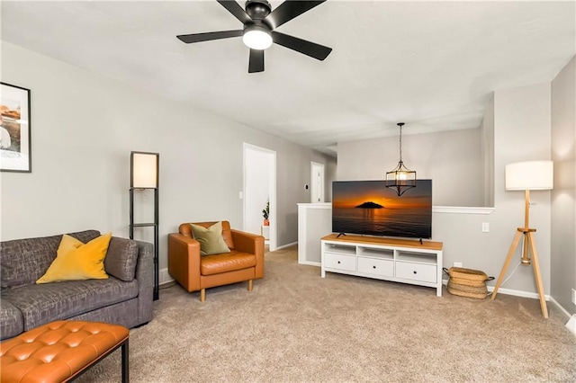 living area featuring baseboards, carpet, and ceiling fan