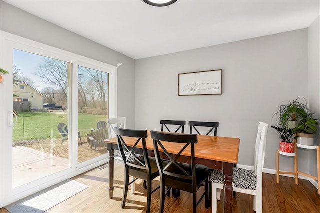 dining area featuring light wood-type flooring and baseboards