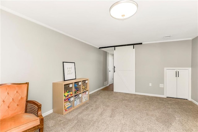 sitting room featuring carpet flooring, baseboards, a barn door, and ornamental molding