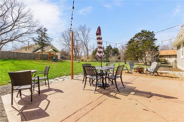 view of patio / terrace with an outdoor fire pit, a fenced backyard, and a playground