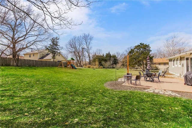 view of yard with a patio, a playground, and a fenced backyard