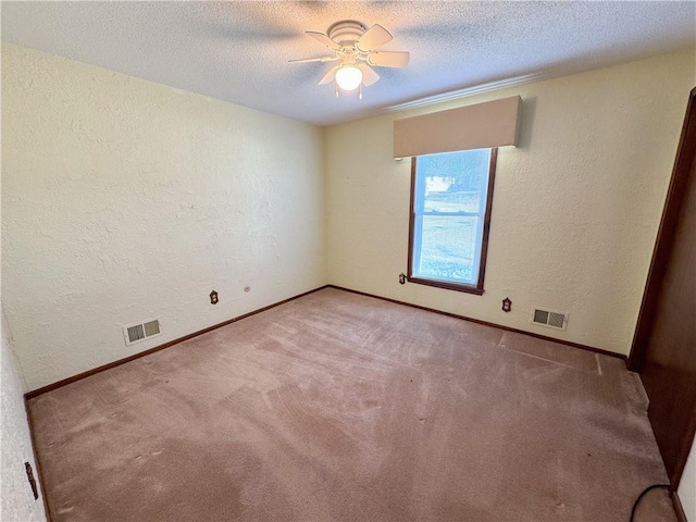 spare room featuring a textured ceiling, a ceiling fan, and a textured wall