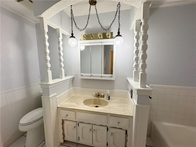 bathroom with toilet, vanity, and a tub to relax in