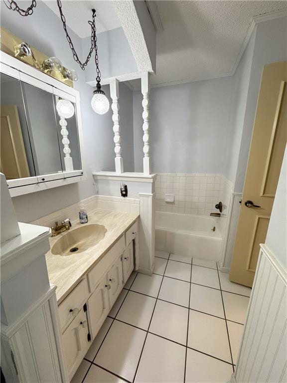 bathroom featuring ornamental molding, a textured ceiling, tile patterned flooring, a bath, and vanity