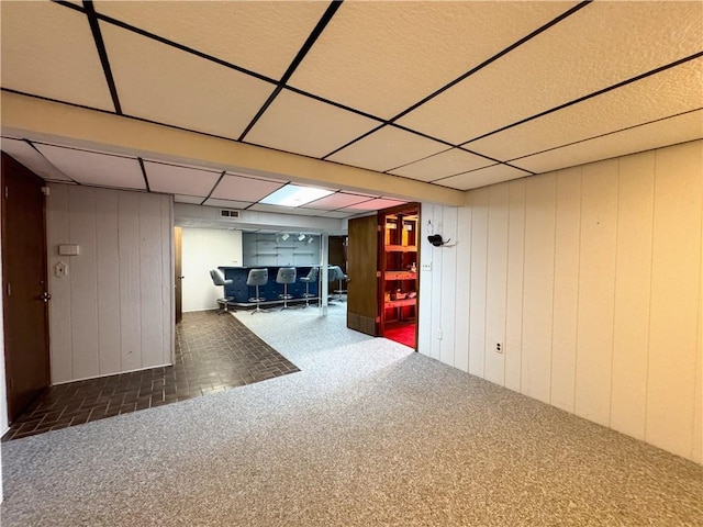 finished basement featuring visible vents, carpet flooring, and a drop ceiling