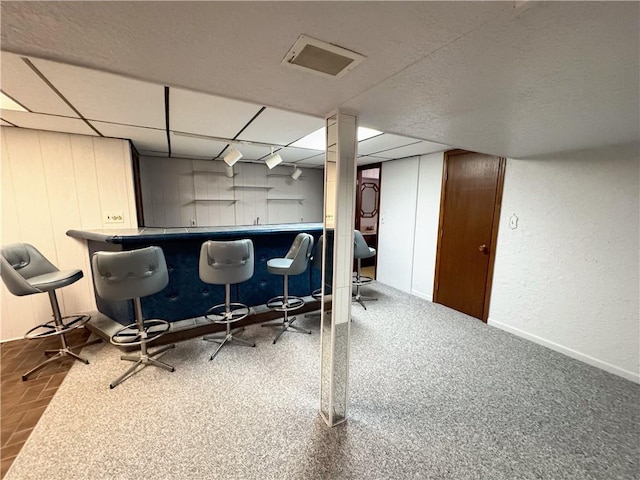 bar featuring visible vents, a paneled ceiling, and a dry bar