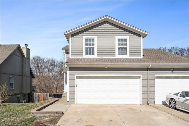 view of front of home with a garage, driveway, and a shingled roof