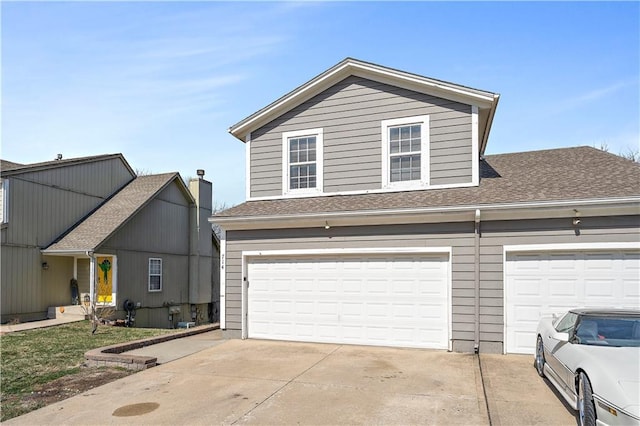 view of front of home with concrete driveway and a shingled roof