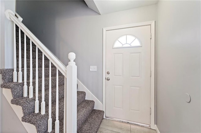 entrance foyer with stairs and baseboards