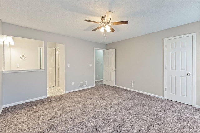 unfurnished bedroom with baseboards, visible vents, carpet floors, and a textured ceiling