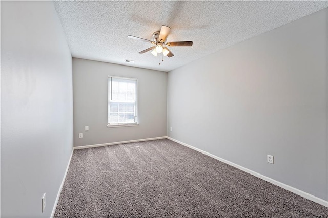 empty room with visible vents, a ceiling fan, a textured ceiling, carpet floors, and baseboards