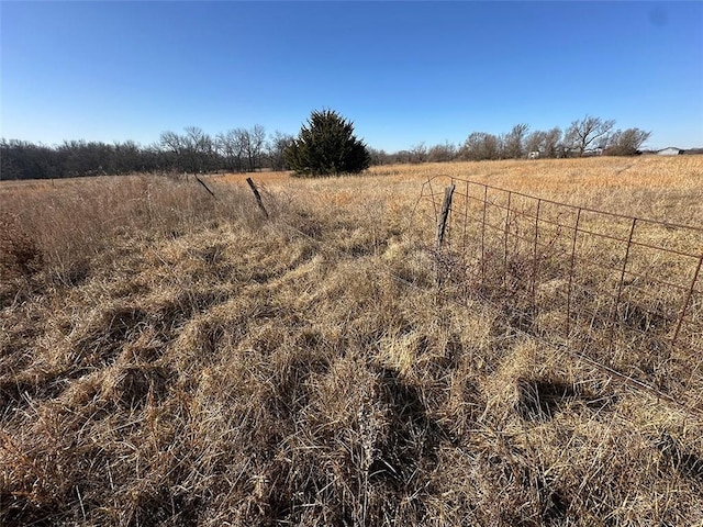 view of yard featuring a rural view and fence