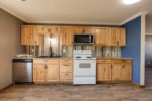 kitchen with dark wood finished floors, ornamental molding, light stone counters, stainless steel appliances, and a sink