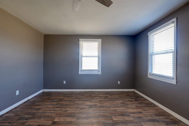 spare room with a healthy amount of sunlight, baseboards, and dark wood-style flooring