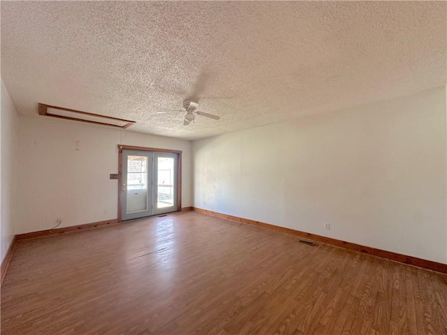 empty room with a ceiling fan, wood finished floors, and baseboards