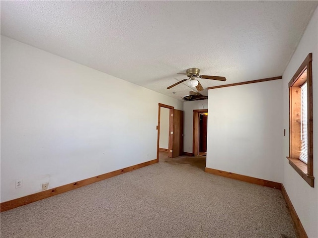 carpeted spare room featuring baseboards and a textured ceiling