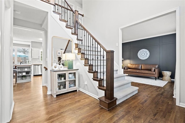 staircase featuring baseboards and wood finished floors