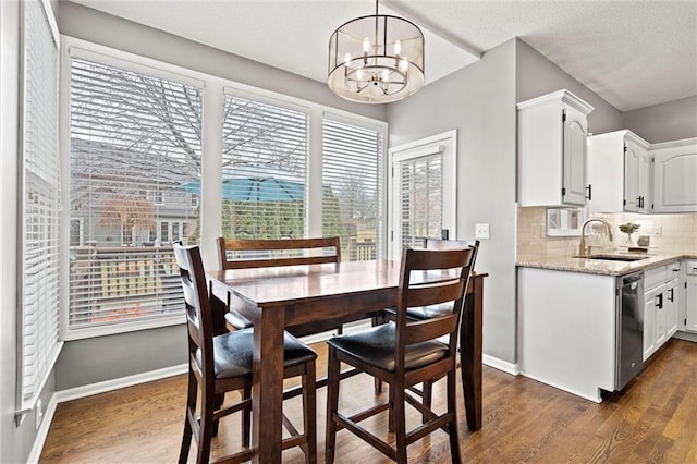 dining area with dark wood finished floors, a notable chandelier, baseboards, and a textured ceiling