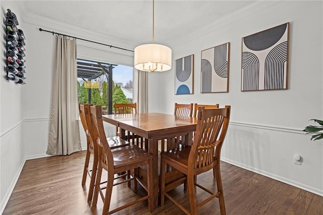 dining area featuring crown molding, baseboards, and wood finished floors