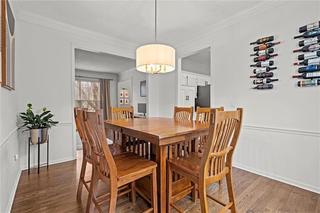 dining space featuring dark wood-style flooring and crown molding